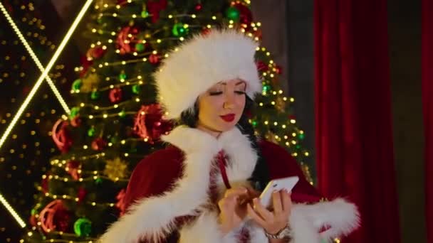 Mujer feliz Sra. Santa hablando por teléfono en su oficina de Navidad. vacaciones en cuarentena. comunicación remota, regalos de vacaciones y descuentos. — Vídeo de stock