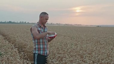 Krivoy Rog, Ukrayna - 07.18.2021 Ukraynalı çiftçi McDonalds burgeriyle buğday tarlasında duruyor