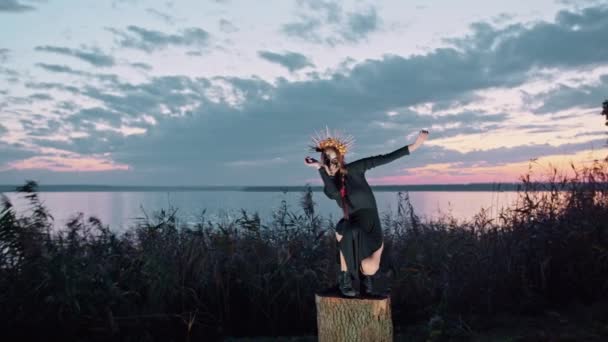 Glückliche junge Frau in Halloween-Kostüm und Schminktänzen in der Natur bei Sonnenuntergang, mystische Filmaufnahmen. — Stockvideo