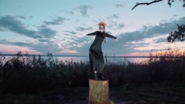 Boldog fiatal nő halloween jelmez és smink táncok a természetben napnyugtakor, misztikus felvétel. — Stock videók