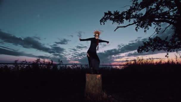 Счастливая молодая женщина в костюме Хэллоуина и макияж танцы на природе во время заката, мистические кадры. — стоковое видео