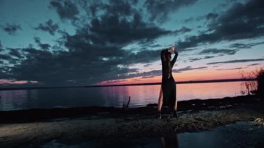 Cadılar Bayramı kostümü içinde mutlu genç bir kadın gün batımında doğada dans ediyor, mistik görüntüler..