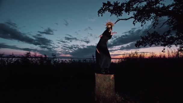 Šťastná mladá žena v halloween kostýmu a make-up tance v přírodě během západu slunce, mystické záběry. — Stock video