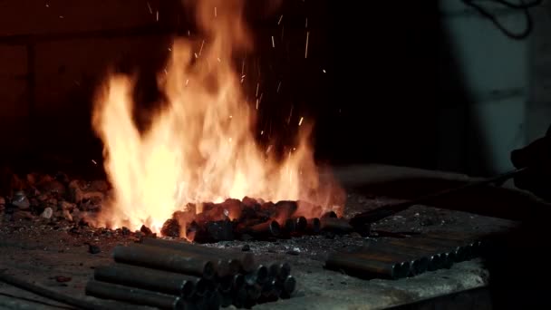 Kowal w kuźni podgrzewa metal w kuźni, przemyśle ciężkim. — Wideo stockowe