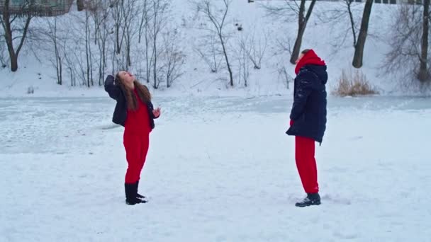 Krivoy Rog, Ukraine - 01.01.22 a young happy woman is having fun in a winter park, throwing snow, it is cold in her hands, the emissions are off scale. — Vídeo de Stock