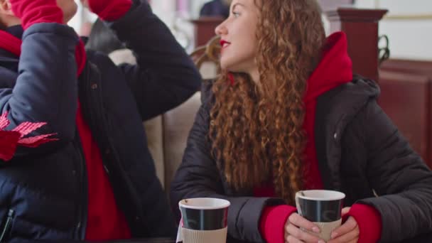 A guy and a girl drink tea in a cafe in winter — Stockvideo