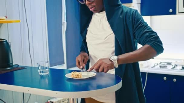Happy black guy eating breakfast at home — Αρχείο Βίντεο