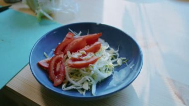 Evde yemek pişirmek. Erkek elleri salatanın üzerine yağ döker, yakın plan. salata hazırlama.