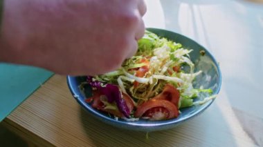Evde yemek pişirmek. Erkek eli salatayı karıştırır, yakın plan. salata hazırlama.