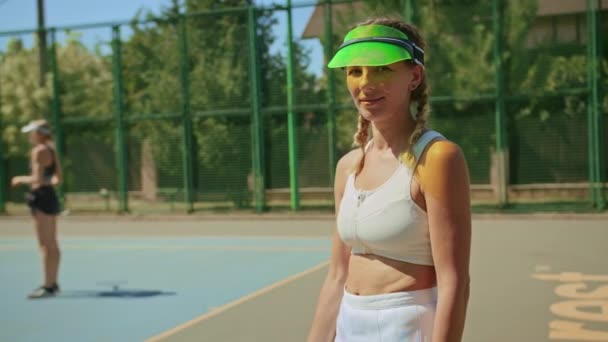 Žena tenis trenér pózování na fotoaparátu stojan na tenisovém kurtu. — Stock video