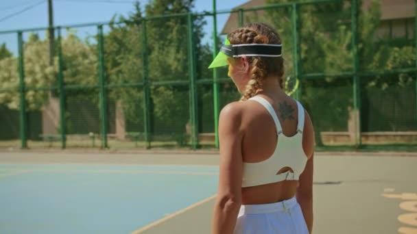 Kvinna tennis tränare poserar vid kameran stå på tennisbanan. — Stockvideo