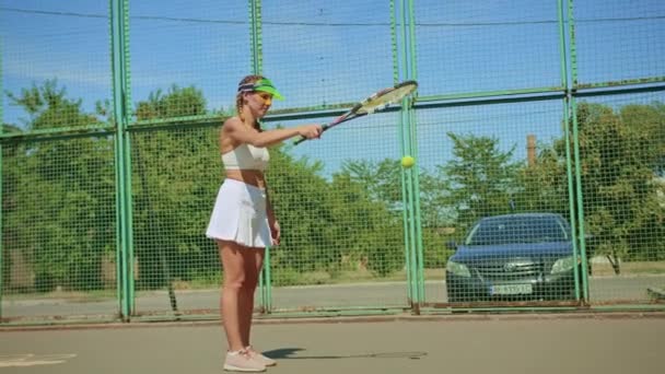 Donna allenatore di tennis in posa presso il cavalletto della fotocamera sul campo da tennis. — Video Stock