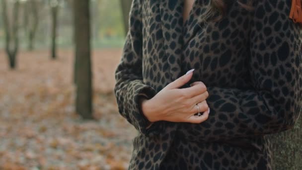 Feliz mujer juguetona en abrigo, sombrero y bufanda en el parque de otoño — Vídeos de Stock