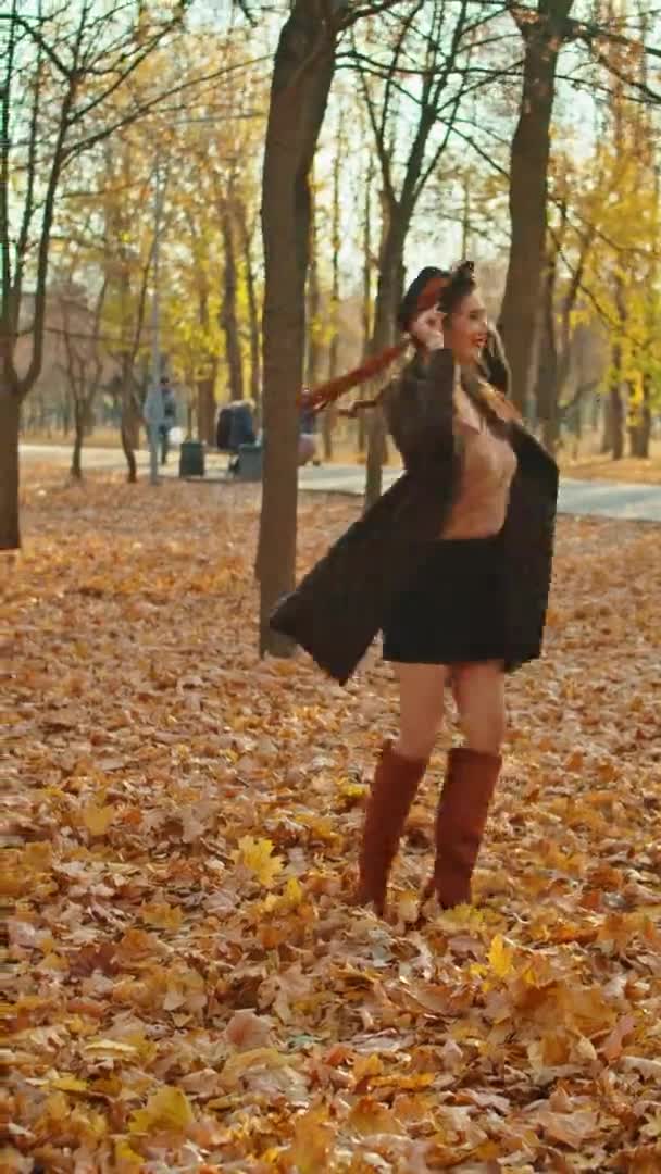 秋の公園のコートと帽子とスカーフを着た幸せな遊び心のある女性 — ストック動画