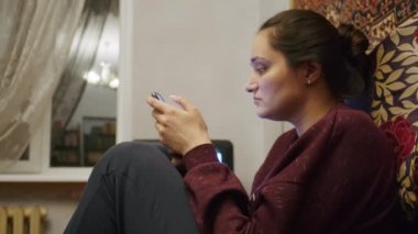 Üzgün bir kız, Ukrayna topraklarındaki Rus saldırısıyla ilgili korkunç haberleri akıllı telefondan izliyor. Ukrayna ve Rusya arasındaki gerginlik hakkında haberler. Rus saldırganlığı. Savaş tehdidi