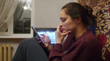 Üzgün bir kız, Ukrayna topraklarındaki Rus saldırısıyla ilgili korkunç haberleri akıllı telefondan izliyor. Ukrayna ve Rusya arasındaki gerginlik hakkında haberler. Rus saldırganlığı. Savaş tehdidi