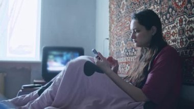 Üzgün bir kız, Ukrayna topraklarındaki Rus saldırısıyla ilgili korkunç haberleri akıllı telefondan izliyor. Ukrayna ve Rusya arasındaki gerginlik hakkında haberler. Rus saldırganlığı. Savaş tehdidi