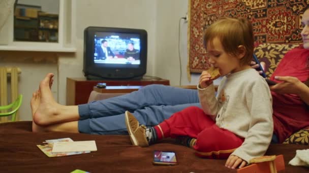 Smutna dziewczyna z rodziną, matką i małym dzieckiem, patrzy na straszne wieści na smartfonie o rosyjskiej ofensywie na terytorium Ukrainy. Wiadomości o napięciach między Ukrainą a Rosją — Wideo stockowe