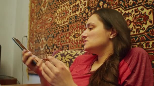 Krivoy Rog, UKRAINE - "RUARI 2022 en ledsen flicka tittar på de fruktansvärda nyheterna på smartphone om den ryska offensiven på territoriet i Ukraina. Nyheter om spänningar mellan Ukraina och Ryssland — Stockvideo