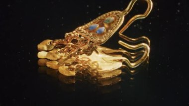 2000 yaşında bir İskitli rahibenin altın küpesi, kazı sırasında bulunan eski bir küpe, dönen bir tekerlek. Klasik mücevherler. Din. yakın plan