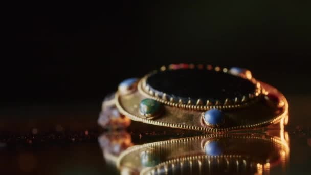 Een gouden broche van een Scythische priesteres van 2000 jaar oud, een oude oorbel, een spinnewiel, gevonden tijdens opgravingen. vintage sieraden. religie. close-up — Stockvideo