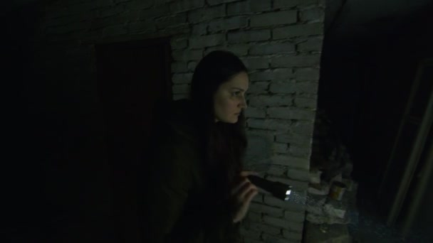 一个处于可怕境地的女孩在一个可怕的地下室里搜寻，以便在发生爆炸时找到一个可能的避难所。关于乌克兰和俄罗斯之间紧张关系的新闻。俄国的侵略战争的威胁. — 图库视频影像