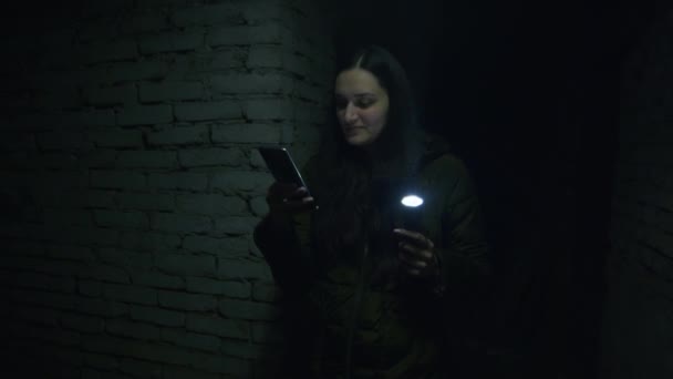 A girl in a terrible state searches a scary basement to find a possible shelter in case of a bomb explosion. News about tensions between Ukraine and Russia. Russian aggression. The threat of war. — Stock Video