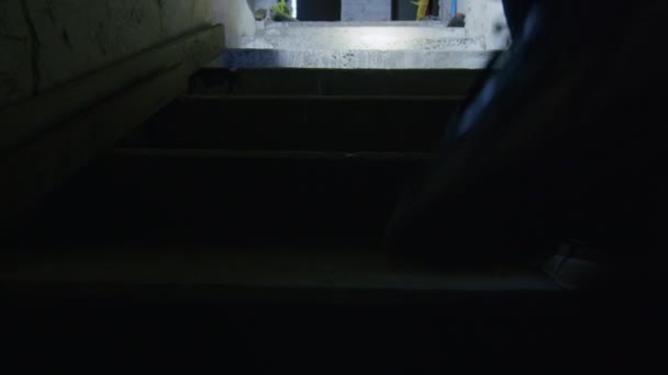 Ein Mädchen in einem schrecklichen Zustand sucht in einem beängstigenden Keller nach einem möglichen Unterschlupf für den Fall einer Bombenexplosion. Nachrichten über die Spannungen zwischen der Ukraine und Russland. Russische Aggression. Kriegsgefahr. — Stockvideo
