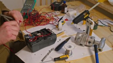 Kryvyi Rih, Ukrayna - Rusya 'nın Ukrayna' ya karşı 2022 yılındaki savaşı. Elektrik bankalarının yetersizliğinden dolayı elektrikçi Ukrayna Silahlı Kuvvetleri için ev yapımı şarj aletleri ve elektrik bankalarını lehimliyordu.