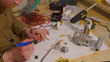 Kryvyi Rih, Ukrayna - Rusya 'nın Ukrayna' ya karşı 2022 yılındaki savaşı. Elektrik bankalarının yetersizliğinden dolayı elektrikçi Ukrayna Silahlı Kuvvetleri için ev yapımı şarj aletleri ve elektrik bankalarını lehimliyordu.
