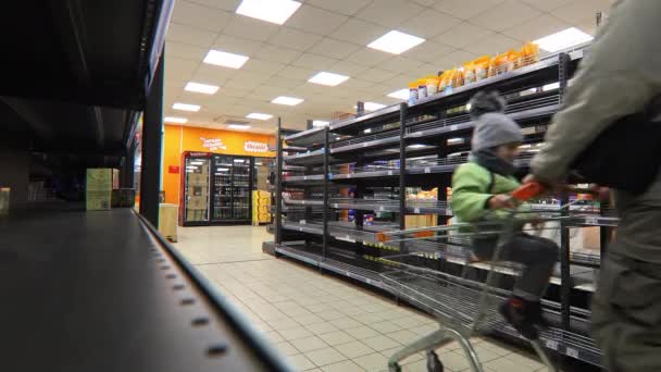 Кривий Ріг, Україна - 2022 батько і дитина йдуть до супермаркету в пошуках їжі. порожні полиці в магазині. наслідки нападу русів на Україну. час війни. — стокове відео