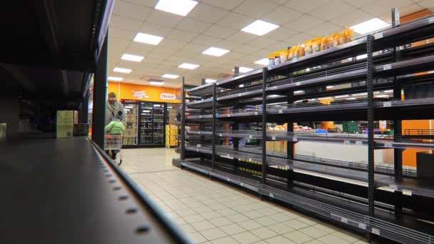 Kligyi Rih,ウクライナ- 2月2022父と子は食べ物を求めてスーパーマーケットに行きます.店内の空き棚。ロシアのウクライナへの攻撃の結果。戦争の時. — ストック動画
