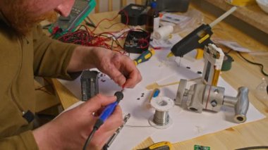 Kryvyi Rih, Ukrayna - Rusya 'nın Ukrayna' ya karşı 2022 yılındaki savaşı. Elektrik bankalarının yetersizliğinden dolayı elektrikçi Ukrayna Silahlı Kuvvetleri için ev yapımı şarj aletleri ve elektrik bankalarını lehimliyordu.