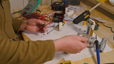 Kryvyi Rih, Ukrayna - Rusya 'nın Ukrayna' ya karşı 2022 yılındaki savaşı. Elektrik bankalarının yetersizliğinden dolayı elektrikçi Ukrayna Silahlı Kuvvetleri için ev yapımı şarj aletleri ve elektrik bankalarını lehimliyordu.
