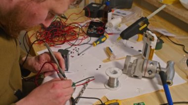 Kryvyi Rih, Ukrayna - Rusya 'nın Ukrayna' ya karşı 2022 yılındaki savaşı. Elektrik bankalarının yetersizliğinden dolayı elektrikçi Ukrayna Silahlı Kuvvetleri için ev yapımı şarj aletleri ve elektrik bankalarını lehimliyordu.