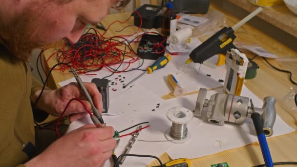 Kryvyi Rih, Ukraine - FEBRUARY 2022 war of Russia against Ukraine. due to the lack of power banks, the guy electrician was soldering home-made chargers and power banks for the Armed Forces of Ukraine — Stock Video