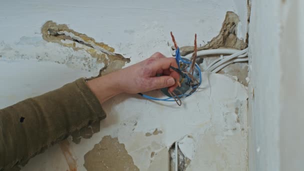 Мужчина-электрик выполняет монтажные работы в квартире перед ремонтом. — стоковое видео