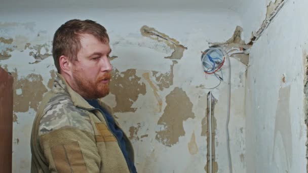 Samec elektrikář provádí instalační práce v bytě před rekonstrukcí. — Stock video