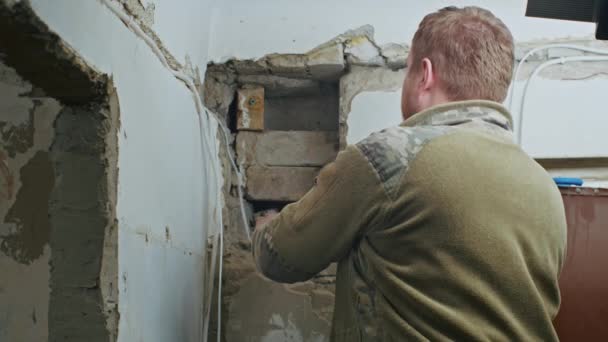 Un electricista masculino realiza trabajos de instalación en un apartamento antes de la renovación. — Vídeos de Stock