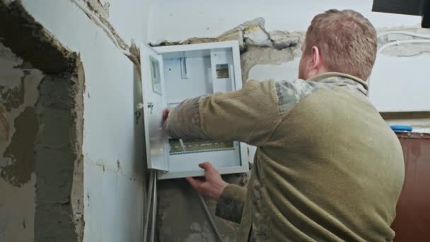 Un electricista masculino realiza trabajos de instalación en un apartamento antes de la renovación. — Vídeos de Stock