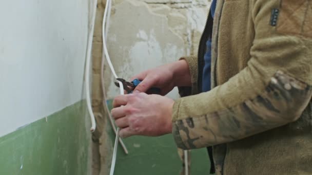 Мужчина-электрик выполняет монтажные работы в квартире перед ремонтом. — стоковое видео