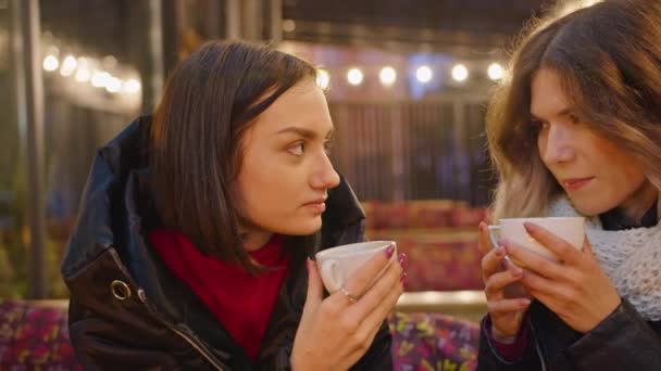 Dvě šťastné ženy spolu tráví čas v kavárně, restauraci, romantickém večeru při svíčkách, lehké atmosféře, životním stylu. pít kávu společně. — Stock video