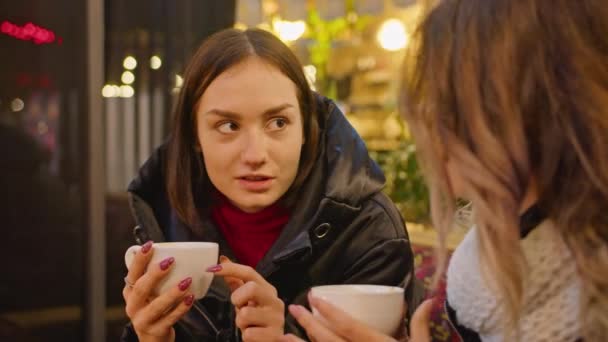 ผู้หญิงสองคนมีความสุขใช้เวลาอยู่ด้วยกันในคาเฟ่ร้านอาหารแสงเทียนเย็นโรแมนติกบรรยากาศแสงไลฟ์สไตล์ ดื่มกาแฟด้วยกัน . — วีดีโอสต็อก