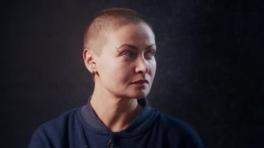 Siyah arka planda Ukraynalı ciddi bir hippinin kameraya mutlu bir yüzle bakması. İnsani duygular, tarz ve modern moda kavramı.