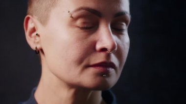 Siyah arka planda Ukraynalı ciddi bir hippinin kameraya mutlu bir yüzle bakması. İnsani duygular, tarz ve modern moda kavramı.