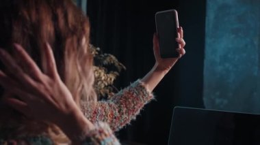 Mutlu kız blogcu kafede otururken telefonla konuşuyor.