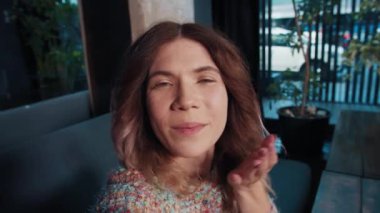 Mutlu kız blogcu kafede otururken telefonla konuşuyor.