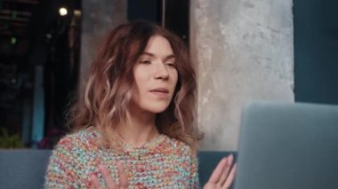 Kafede oturup dizüstü bilgisayarla konuşan mutlu blogger kızı.