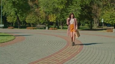 Gözlüklü genç mutlu kadın parkta yürüyor. sonbahar yaz dönemi.