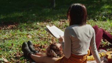 İki mutlu genç kadın şehir parkında otururken eğleniyor. Genç ve mutlu bir hayat. Bir kız kitap okur, ikincisi ayaklarının üstünde yatar..